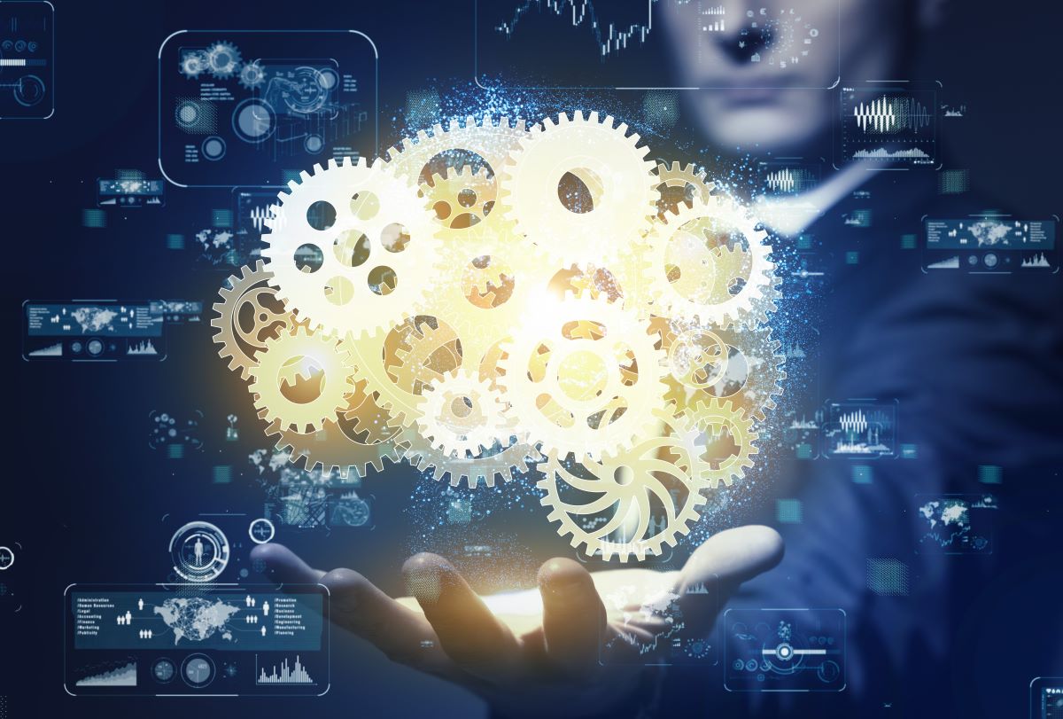 A hand holding a set of gold cogs with a futuristic background.